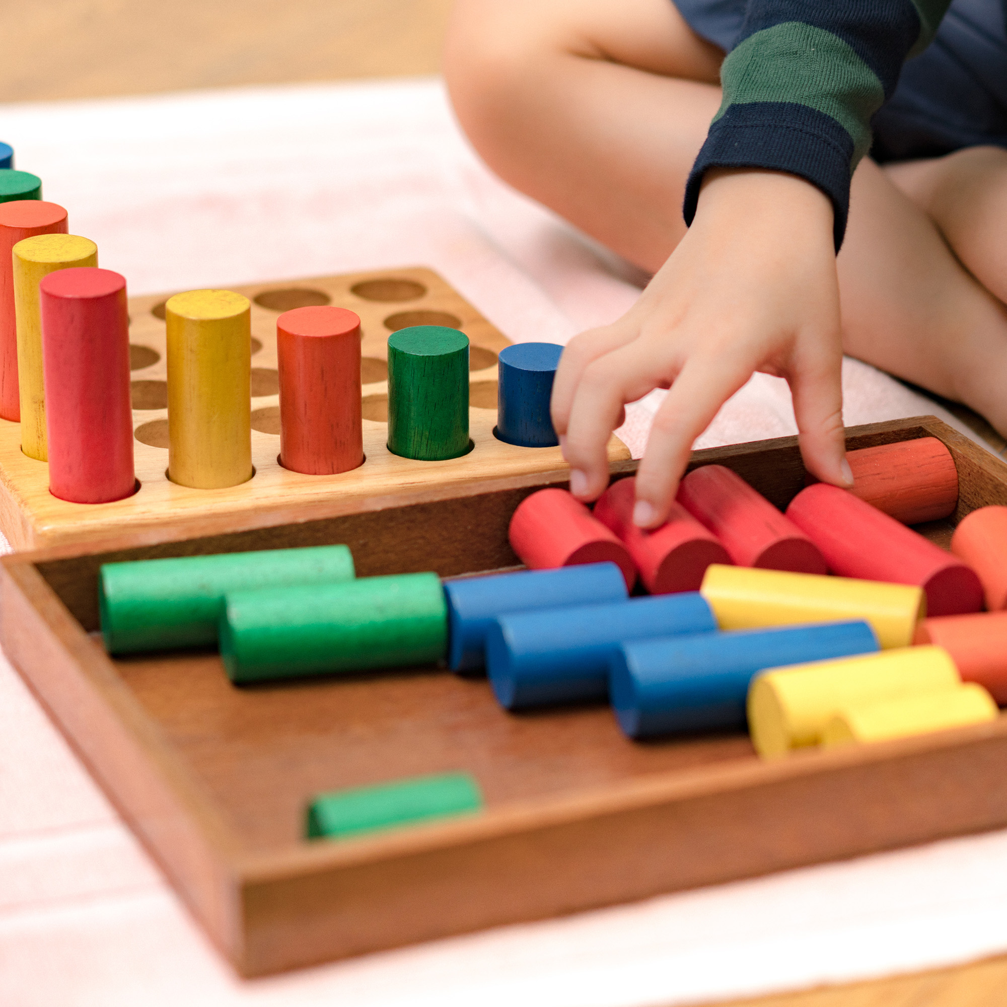 Closeup: Hands of a little Montessori kid (3-6) learning about s